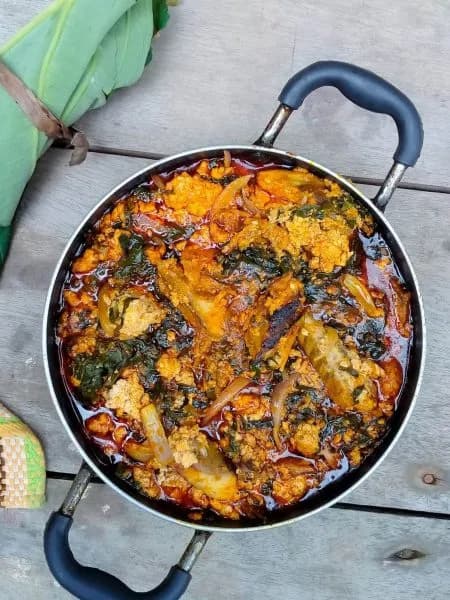 Kontomire stew, a Ghanaian cocoyam leaf stew thickened with ground melon seeds, served with boiled yam