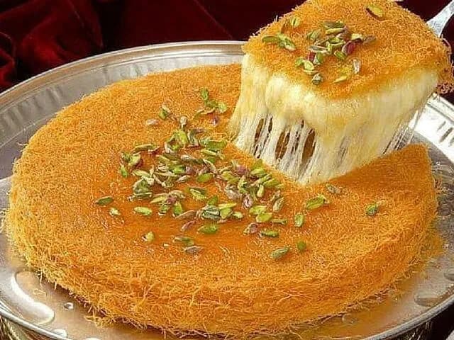 Kunafa, shredded kataifi pastry baked golden with a cream filling and pistachio