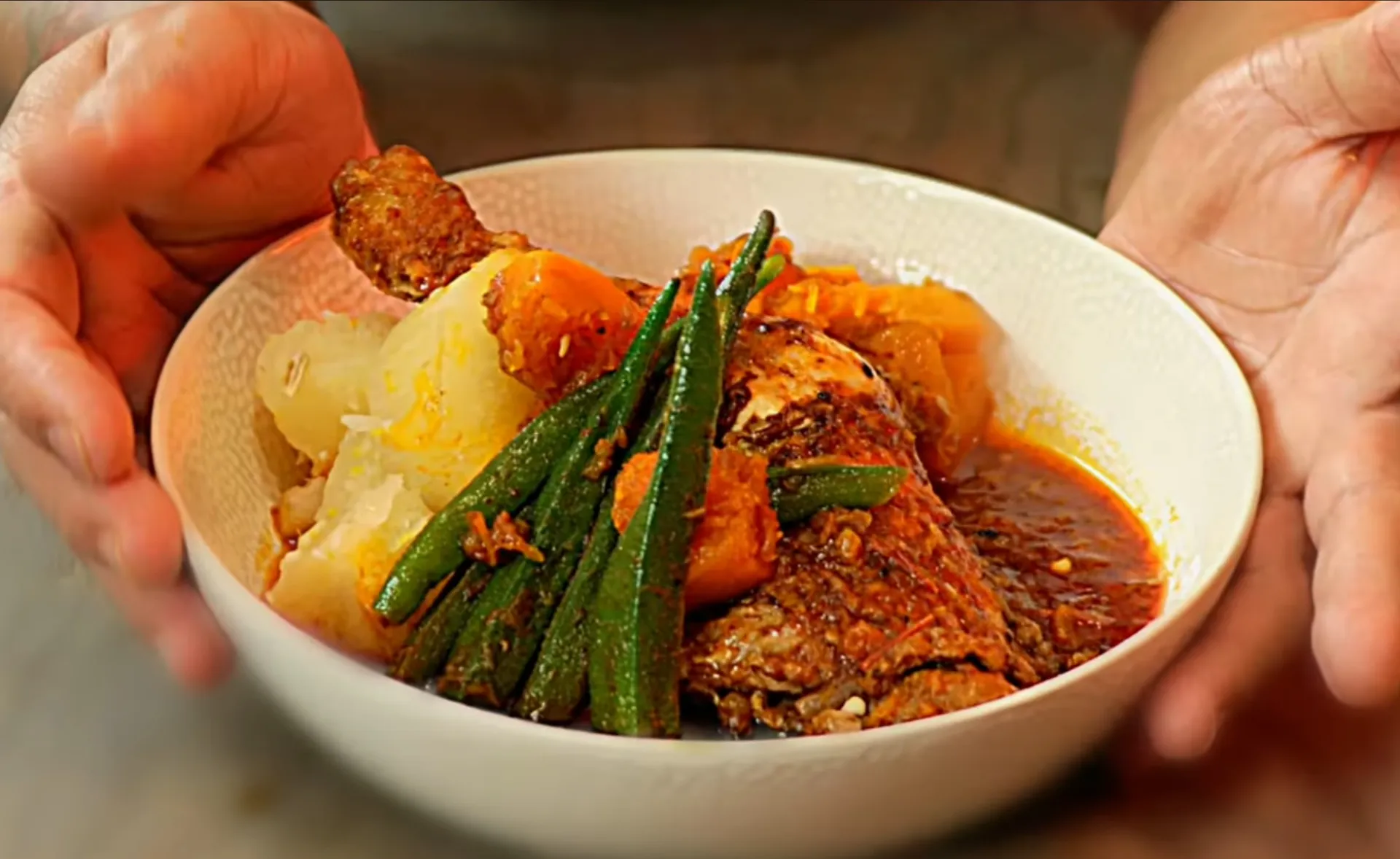 Muamba de galinha, an Angolan chicken stew cooked in red palm oil with okra and squash