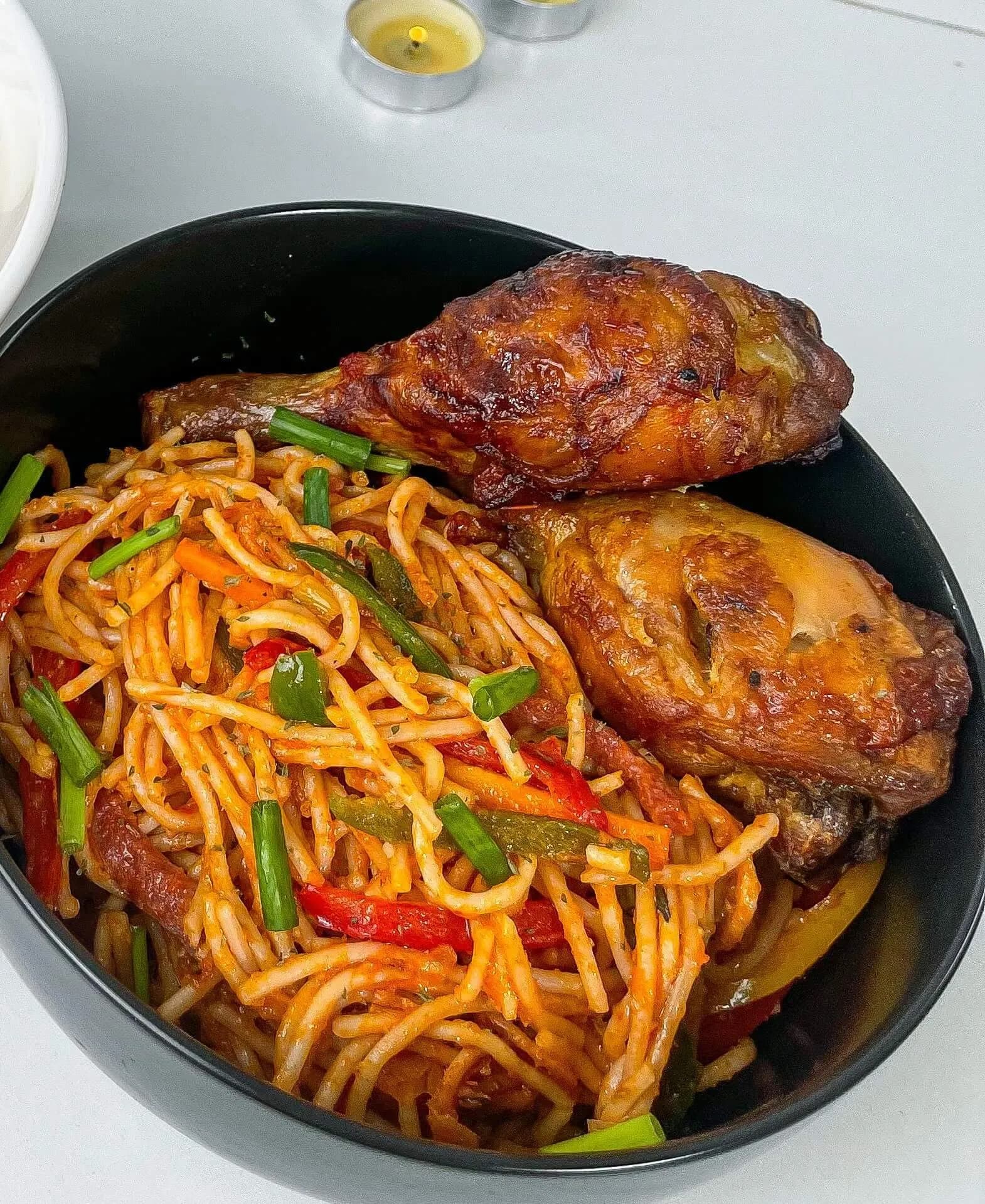 Nigerian jollof spaghetti cooked in a blended pepper sauce with sausage, bell pepper and carrot