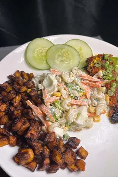 A Nigerian style pasta salad with macaroni, carrots, sweetcorn, peas and boiled egg in a mayonnaise dressing