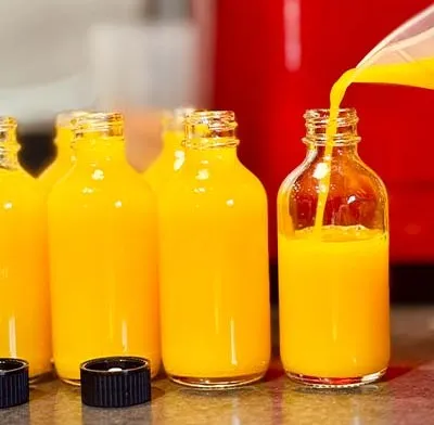 Pineapple, turmeric and ginger juice, a bright yellow cold pressed juice in glass bottles