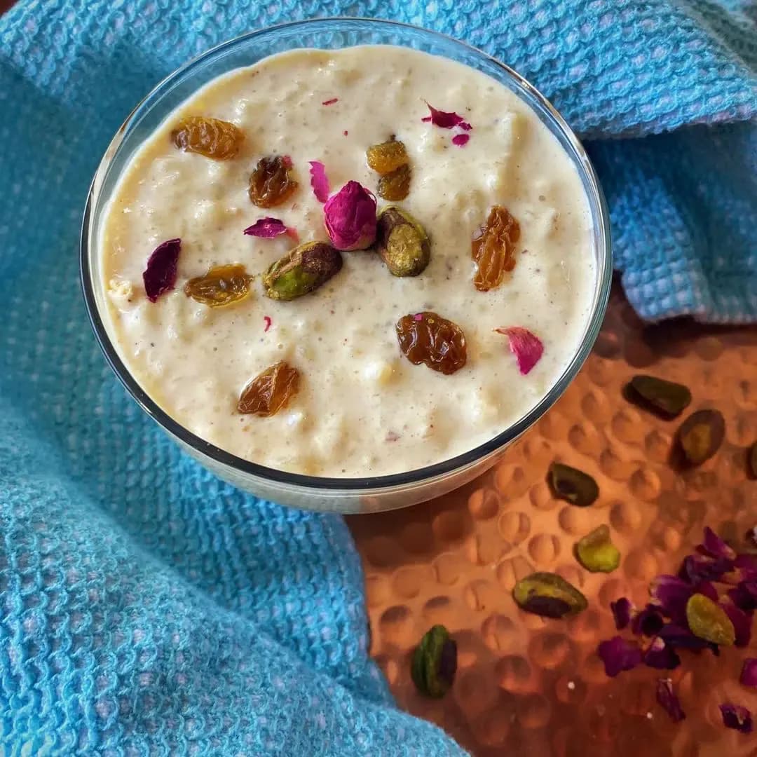 Roz bi laban, an Egyptian rice pudding served in a bowl with cinnamon and chopped almonds