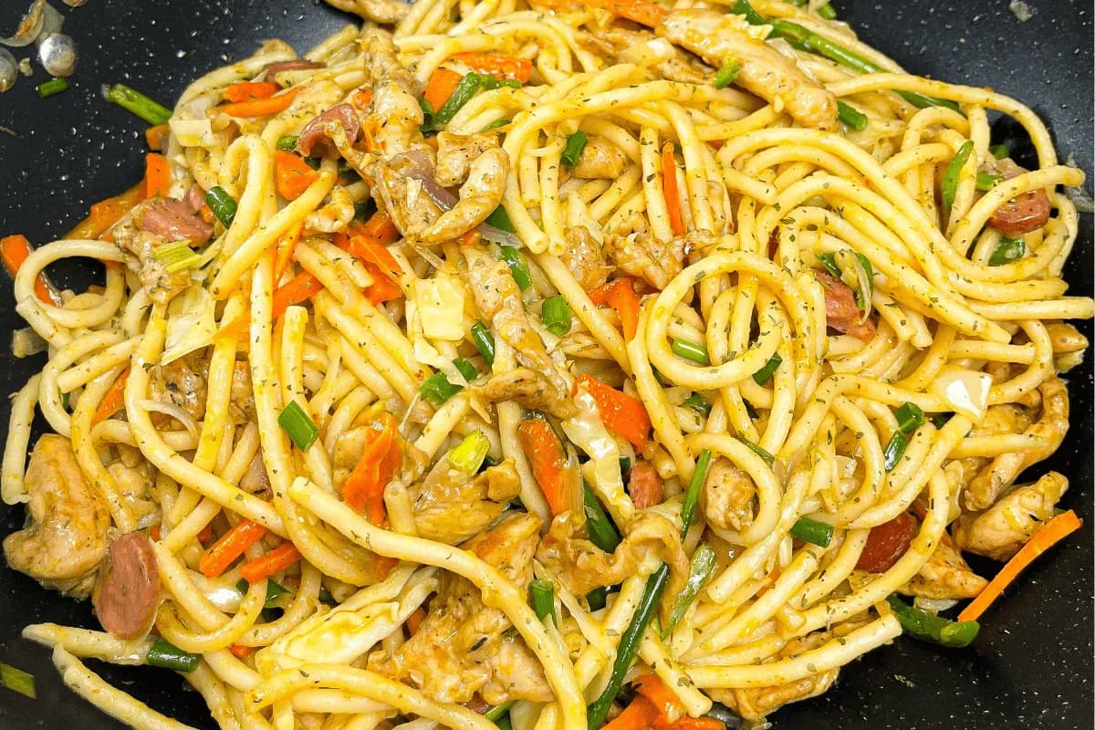 Stir fry spaghetti with sausage, cabbage, carrot and bell pepper in a savoury sauce