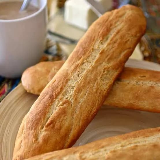 Tapalapa, a scored West African bread loaf with a firm crust, torn open