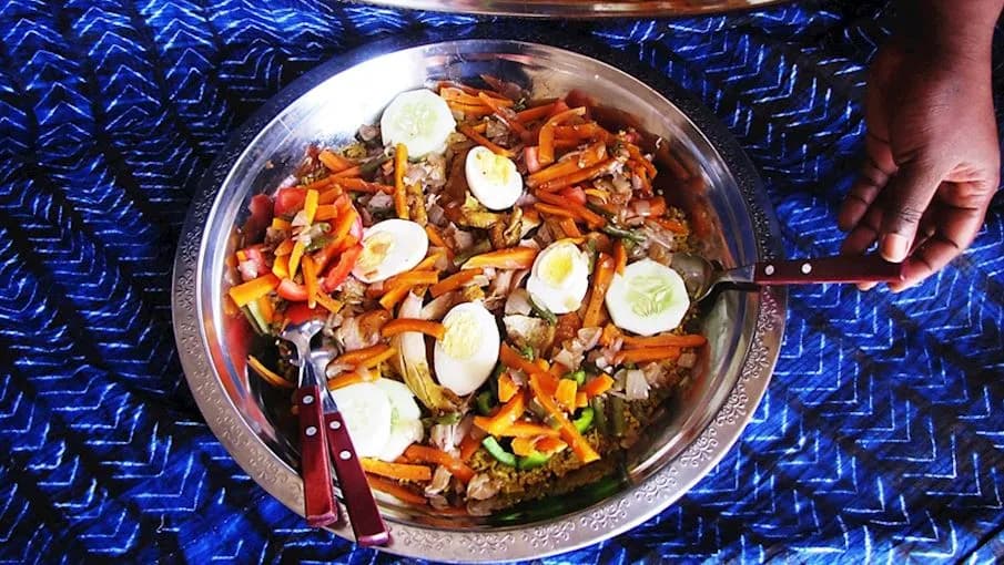 Thiébou yapp, a Senegalese rice dish cooked in seasoned broth with beef and chicken and served on a communal platter