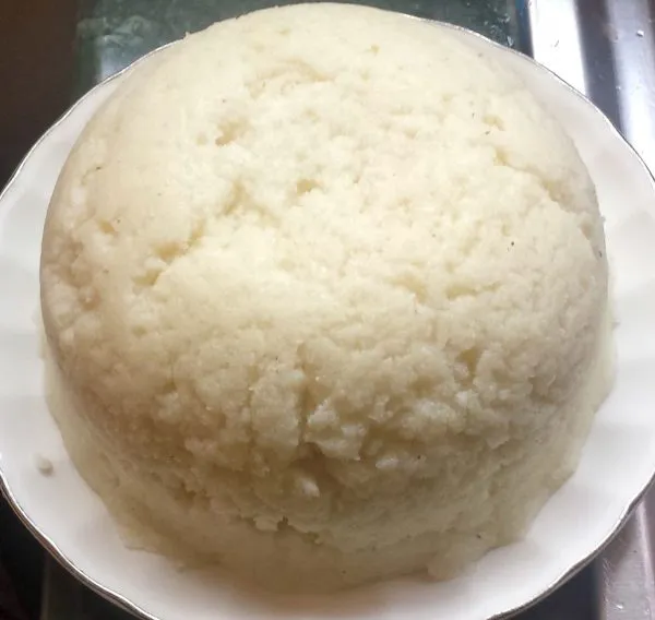 Ugali, a firm East African white maize meal staple, shaped into a mound and served with stew