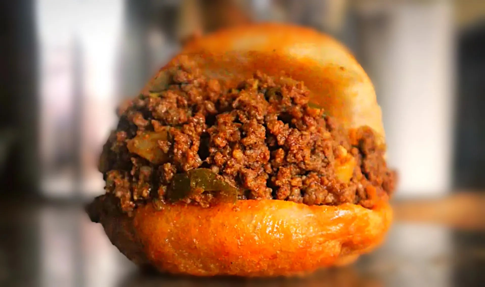 Vetkoek, South African fried bread also known as amagwinya, split and filled with curried beef mince