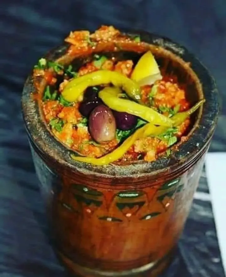 Zviti, a fiery Algerian dish of crumbled semolina flatbread crushed with grilled peppers in a wooden mortar